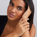 Woman wearing a diamond ring with a neutral background