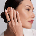 Profile of a woman with a Rittenhouse Bezel-Set Onyx Ring featuring a large black stone in a gold frame, on her finger.