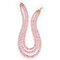 Pink beaded necklace with gold clasp on a white background