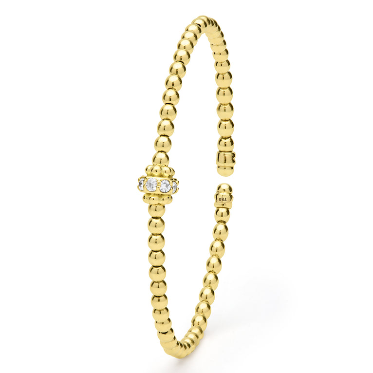 Gold beaded ring with a small diamond on a white background