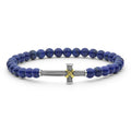 Blue beaded bracelet with a silver and gold cross charm on a white background
