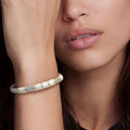 Woman wearing the Two-Tone Five Station White Ceramic Versa Torque Bracelet