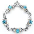 Five swiss blue topaz emerald-cut gemstones, with 18k gold and sterling silver detailing form this bracelet.