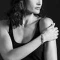 Woman wearing the Rittenhouse Medium Prasiolite Caviar Bracelet with green gemstone, sterling silver Caviar beading, and 18K gold detailing on her wrist.