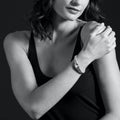 Woman wearing a sleeveless top holds shoulder, showcasing the Rittenhouse Prasiolite Caviar Bracelet 9mm. Features a bezel-set prasiolite gemstone with sterling silver and gold detailing.
