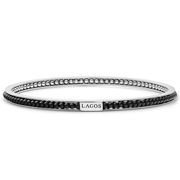 Onyx gemstone beading set with smoothly polished sterling silver forms this round bangle detailing the LAGOS logo.