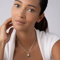 Woman wearing the Rare Wonders Jade Beetle Diamond Pendant Necklace with a silver chain and jewel-encrusted beetle pendant, showcasing LAGOS elegant craftsmanship.