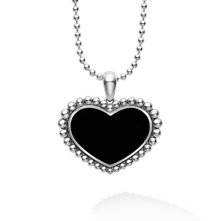An onyx gemstone pendant framed by sterling silver Caviar beading in the shape of a heart finished on a ball chain necklace.