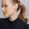Woman wearing Caviar Gold Six Graduated Bead Drop Earrings in 18K gold, featuring six graduated round stations.