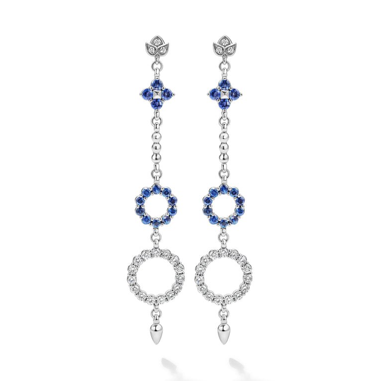 These earrings showcase a dazzling cascade of diamonds and blue sapphires, inspired by the delicate beauty of the lotus flower.