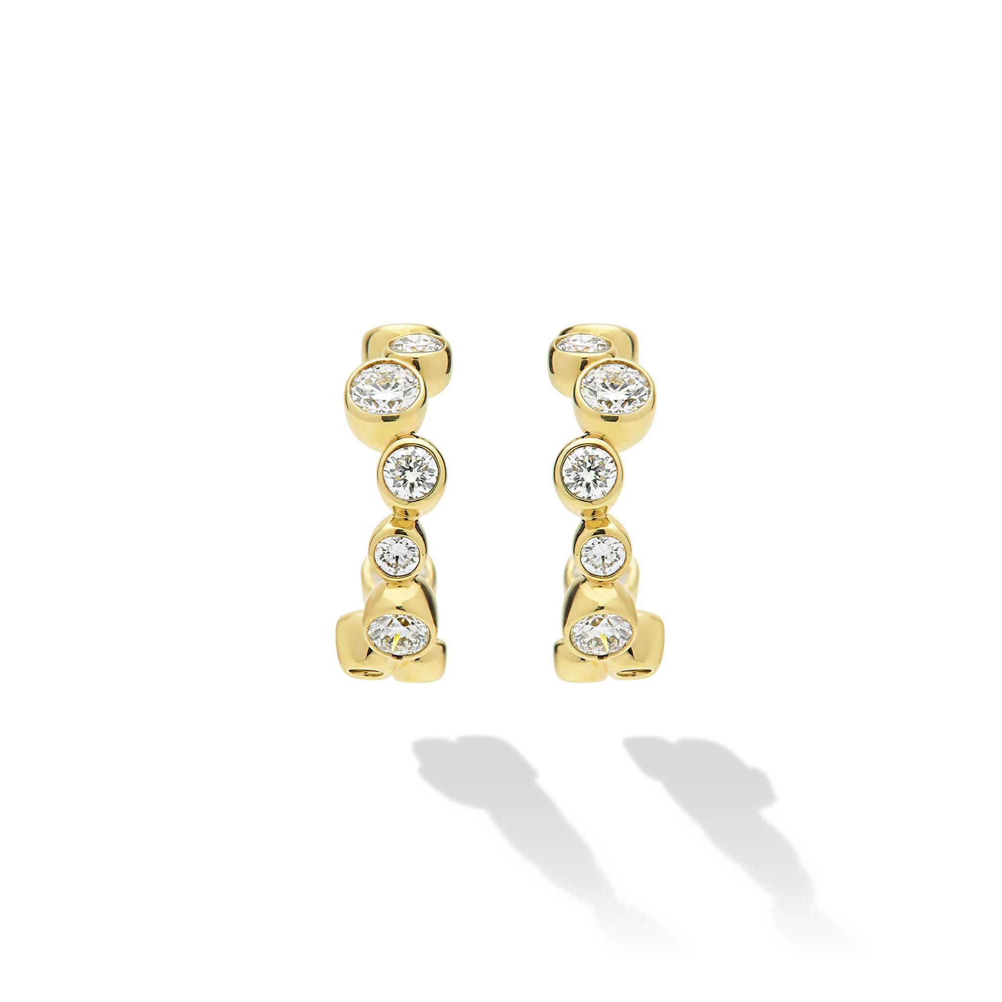 18K Gold huggie earrings with bezel-set diamonds on white background 