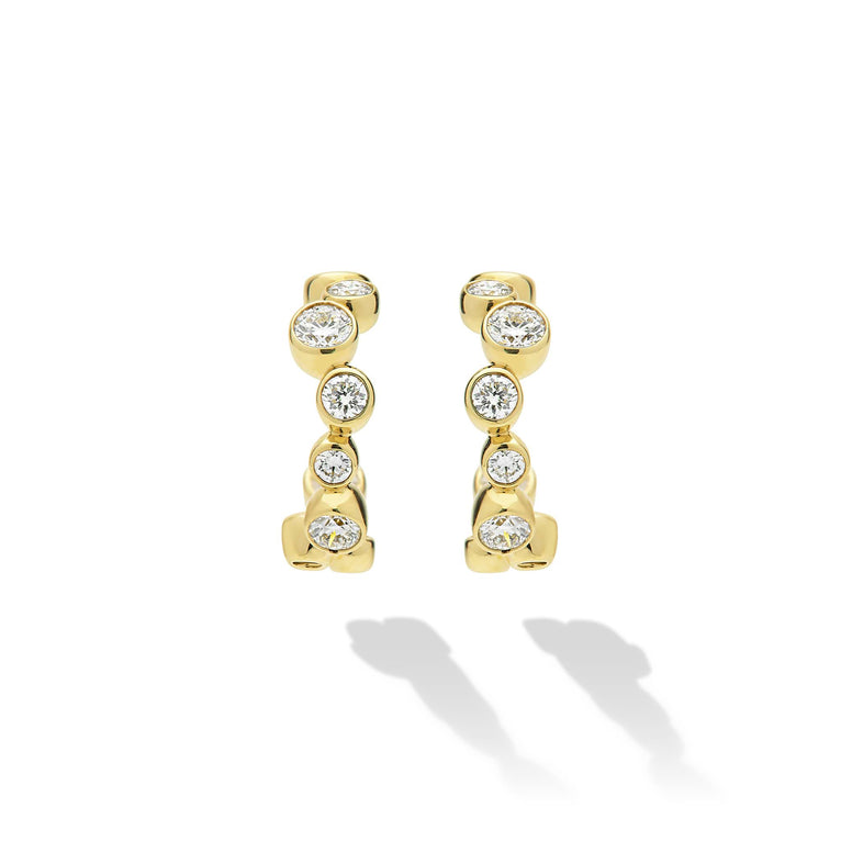 18K Gold huggie earrings with bezel-set diamonds on white background 
