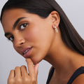 woman wearing nine diamonds drop earrings set in gold on a white background