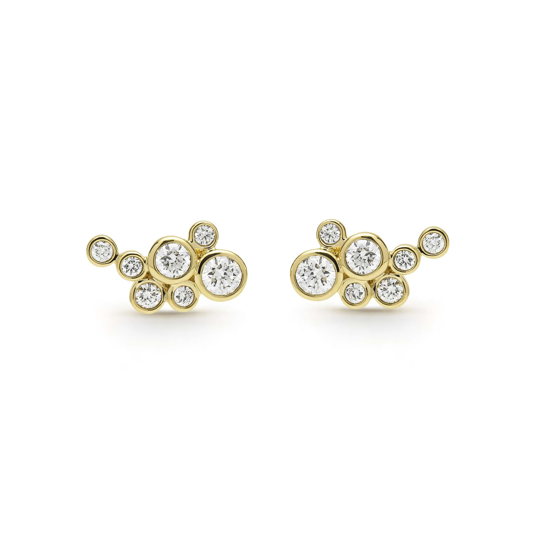 seven bezel-cut diamond stud earrings set in 18K gold on a white background