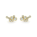 seven bezel-cut diamond stud earrings set in 18K gold on a white background