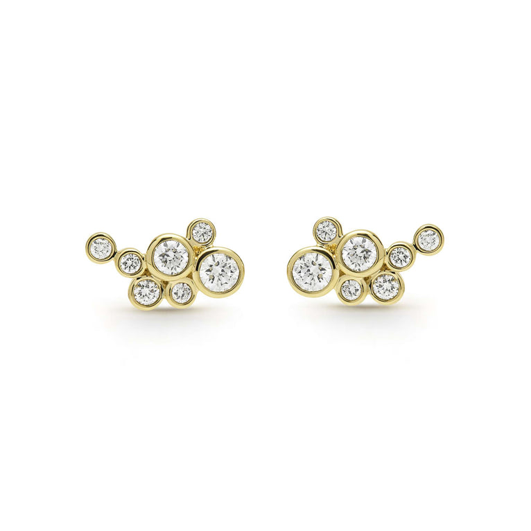 seven bezel-cut diamond stud earrings set in 18K gold on a white background