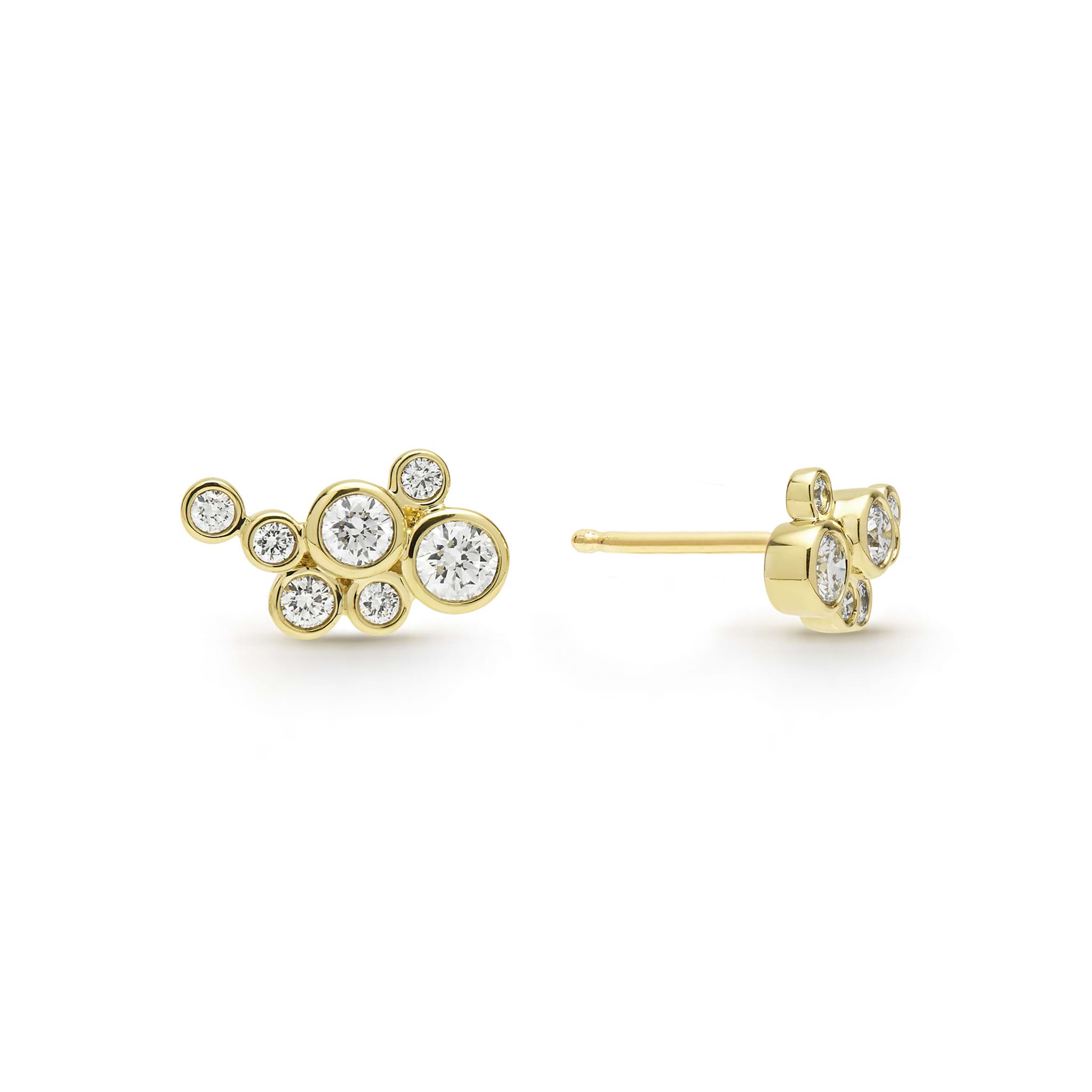 seven bezel-cut diamond stud earrings set in 18K gold with post on a white background