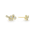 seven bezel-cut diamond stud earrings set in 18K gold with post on a white background