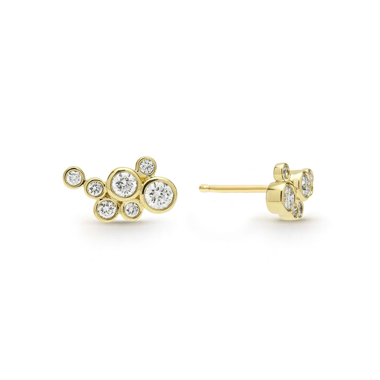 seven bezel-cut diamond stud earrings set in 18K gold with post on a white background