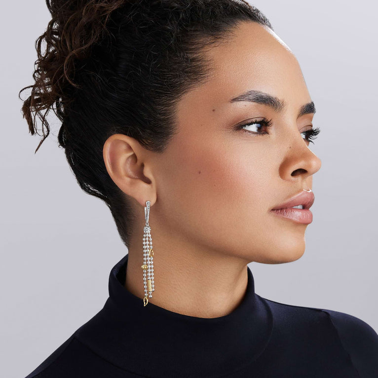 Caviar Icon Two-Tone Caviar Tassel Earrings in silver and gold, featuring intricate beading and tassel design, elegantly accentuating the wearers profile.