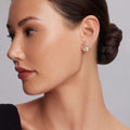Woman wearing Beloved Two-Tone Lock Crest Stud Earrings, featuring sterling silver with an 18k gold LAGOS crest, highlighting elegance and quality against a softly lit background.