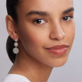 Woman wearing Signature Caviar Sterling Silver Caviar Drop Earrings with three graduated beaded spheres, highlighting her smooth skin and elegant style.