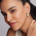 Close-up of a face showcasing the High Bar Two-Tone Caviar Omega Clip Earrings, featuring 18K gold with sterling silver caviar beading.