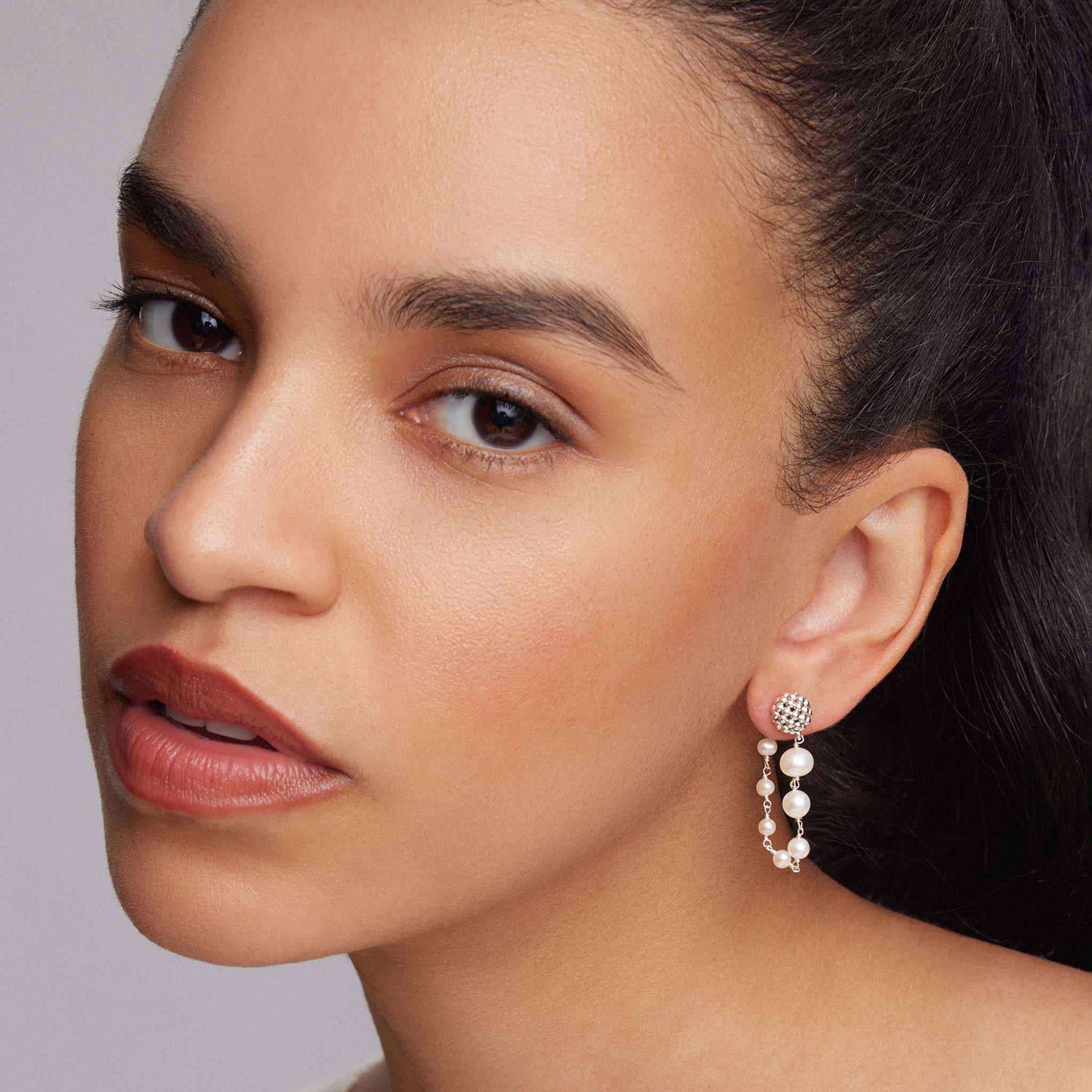 Woman wearing Pearl Drop Earrings with the ended connecting