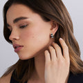 woman wearing side of sterling silver beaded huggie earrings with black ceramic and diamond details