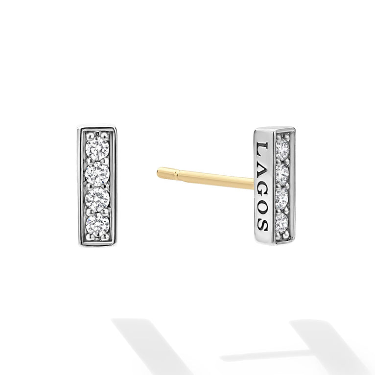 Caviar Spark Silver Linear Diamond Stud Earrings feature a silver bar with diamonds and a yellow-gold post, engraved with LAGOS, embodying minimalist elegance and quality craftsmanship.