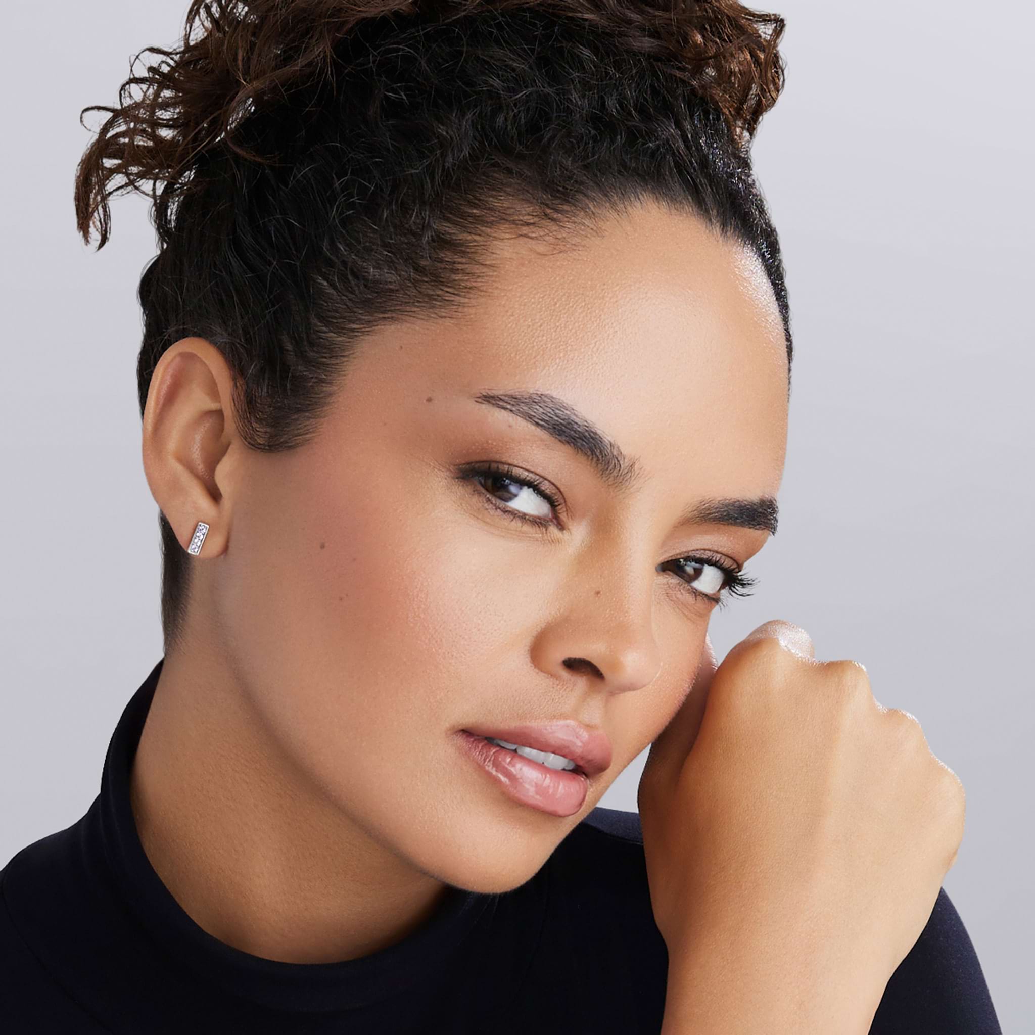 Close-up of a young woman wearing Caviar Spark Silver Linear Diamond Stud Earrings, showcasing their sleek, minimalist design with brilliant diamonds in sterling silver.