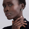 Black Ceramic Caviar Omega Clip Earrings on a person, featuring textured silver halves and a smooth band, showcasing LAGOS signature elegance and craftsmanship.