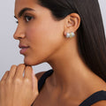 woman wearing sterling silver huggie earrings with gold details and diamonds