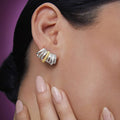 woman wearing everyday sterling silver huggie earrings with gold details and diamonds