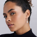 Profile view of a woman showcasing Luna Sterling Silver Pearl Drop Earrings, featuring a large pearl suspended from a silver Caviar setting, highlighting modern elegance.