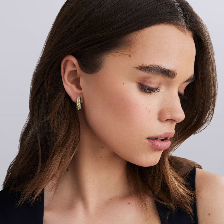 woman wearing everyday gold beaded with sterling silver huggie earrings 