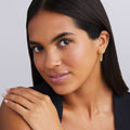 Caviar Lux Two-Tone Mini Caviar Hoop Earrings shown on a woman, highlighting the earrings textured gold detail and elegant design.