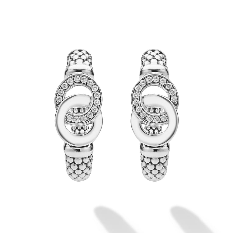 Signature Caviar Silver Interlocking Diamond Hoop Earrings feature two interlocking oval loops with polished and crystal-set textures, suspended from a beaded hinge.