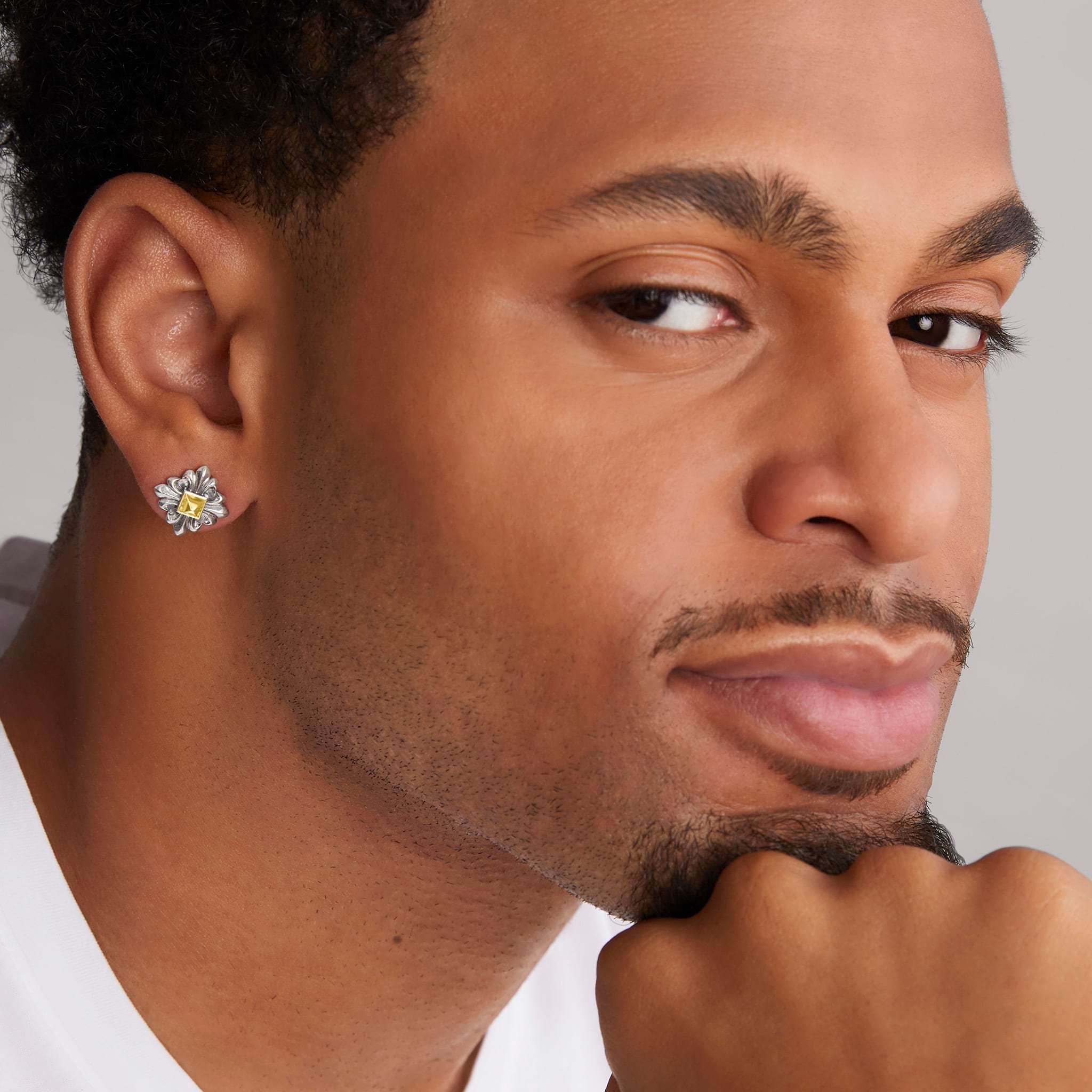 man wearing sterling silver and 18K gold stud earring with pyramid center