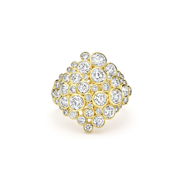 front of cluster diamond set in 18K gold statement ring on white background