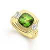 Featuring a cushion-cut peridot gemstone, framed by two baguette diamonds, the 18k gold setting highlights the vibrant green hues of peridot, creating a sophisticated and eye-catching piece.