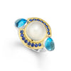 Moonstone, blue sapphire, and blue topaz gemstones are set in smooth 18k gold and sterling silver to form this statement ring.