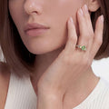 Woman showcases the Signature Caviar Two-Tone Peridot Oval Ring, featuring a vibrant green peridot set in sterling silver with 14K gold accents.