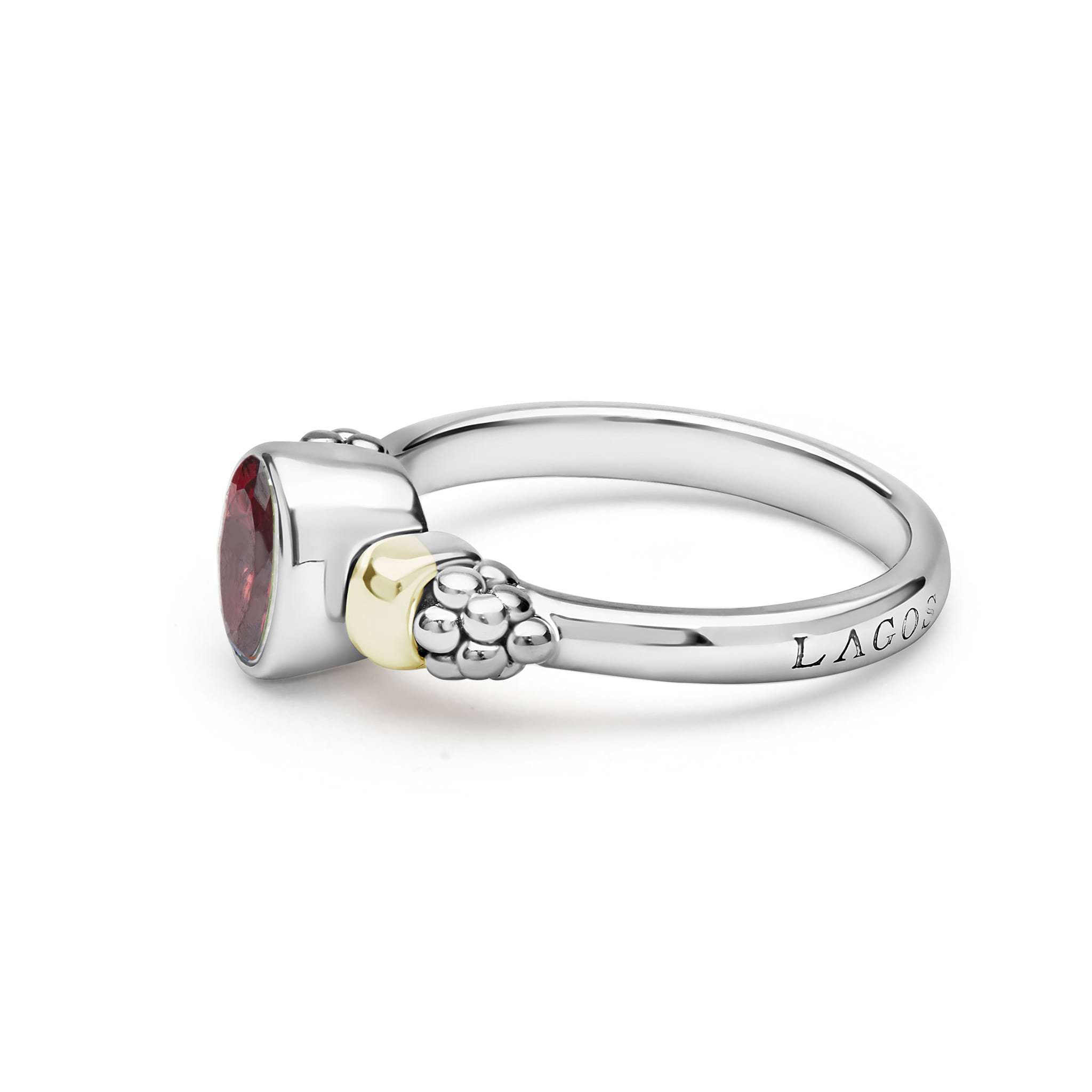 Signature Caviar Two-Tone Garnet Oval Ring in sterling silver and 14K gold, featuring a bezel-set faceted red gemstone with caviar beading and LAGOS engraving.