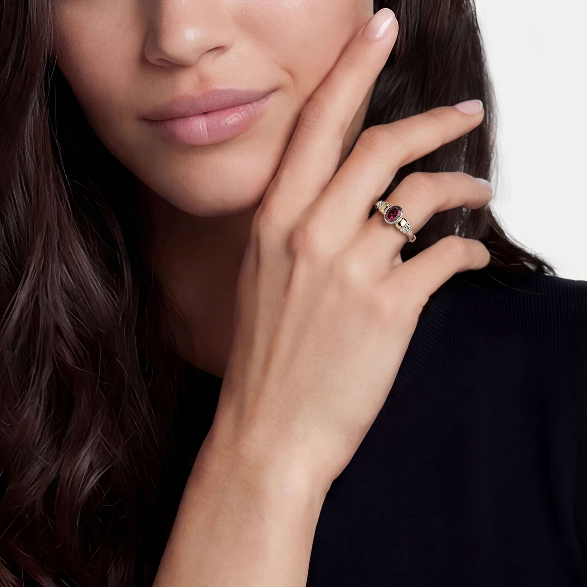 Woman wearing the Signature Caviar Two-Tone Garnet Oval Ring featuring a deep red gemstone set in 14K gold and sterling silver.