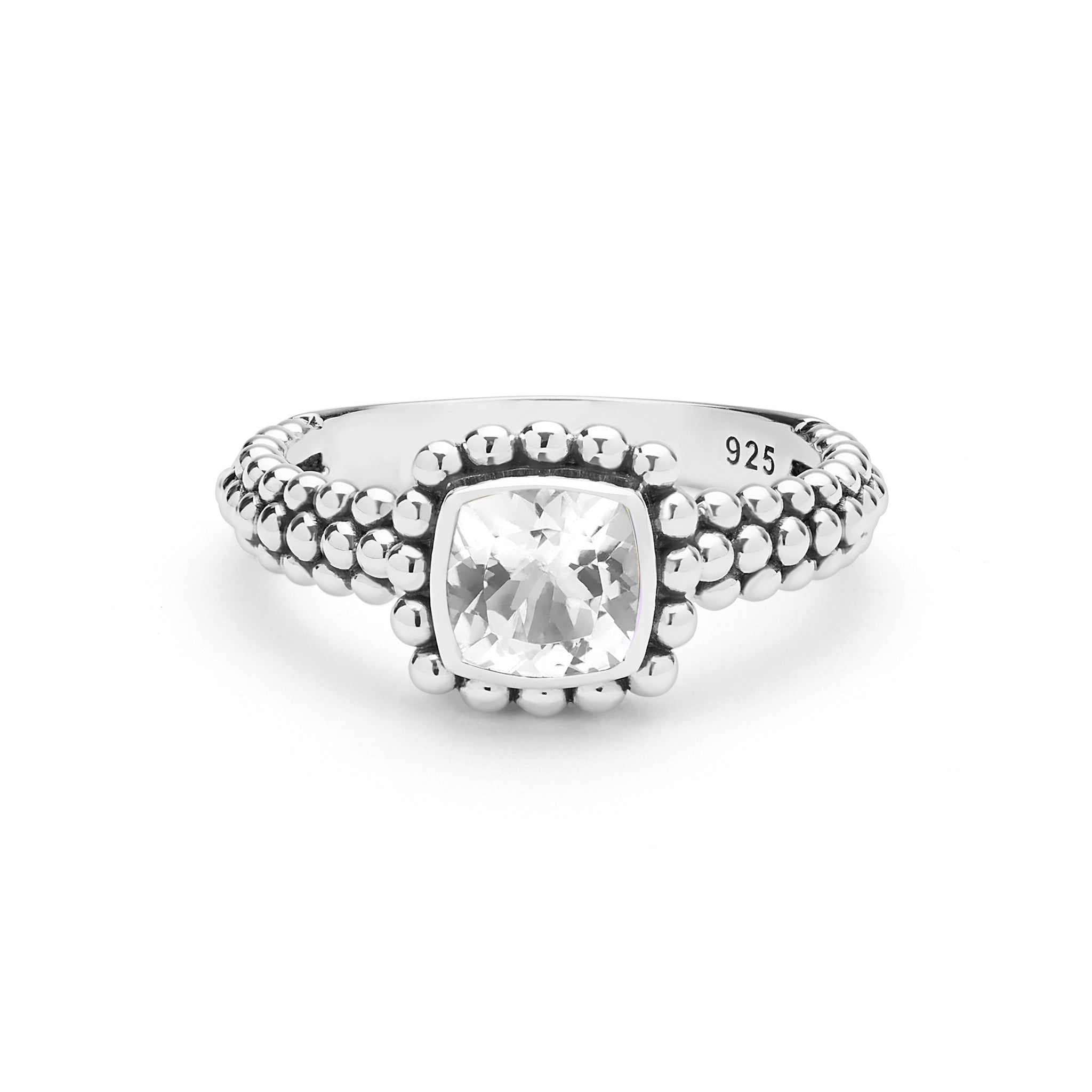 A silver ring featuring a cushion-cut white topaz gemstone in a bezel setting, surrounded by a halo of small round beads and a textured beaded band. 