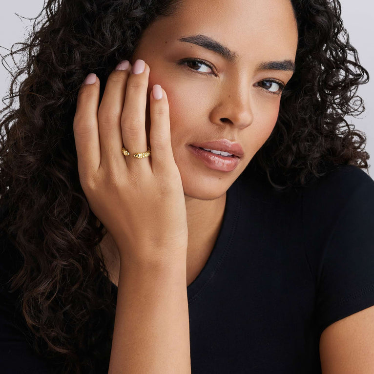Woman wearing Signature Caviar 18K Gold Mini Versa Stacking Ring on hand, showcasing LAGOS craftsmanship and elegance.