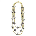 Tahitian black pearl stations highlighted on a 18K gold beaded necklace.