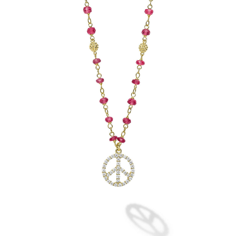 18k gold and ruby gemstones accented with round diamonds in a peace sign motif form this pendant necklace. LAGOS diamonds are the highest quality natural stones.