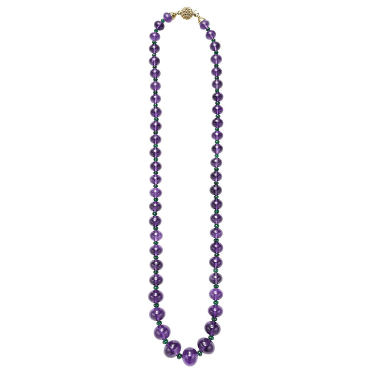 18k gold, smooth amethyst cabochon, and tsavorite garnet gemstones form this statement necklace.